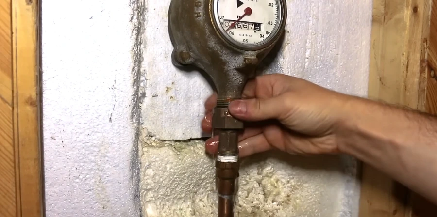Hand checking a water meter during a slab leak investigation in Clifton NJ